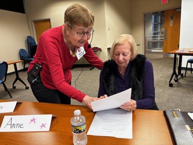 teacher helping student in classroom