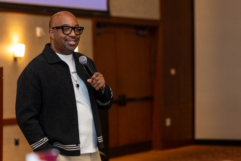 Kwame Alexander speaks into a hand-held microphone.